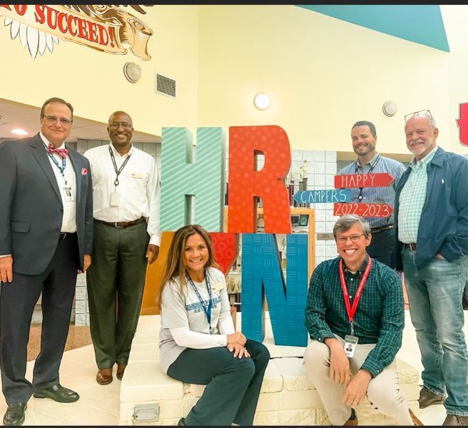  five board members with superintendent Dr. Ed Nichols in front of school